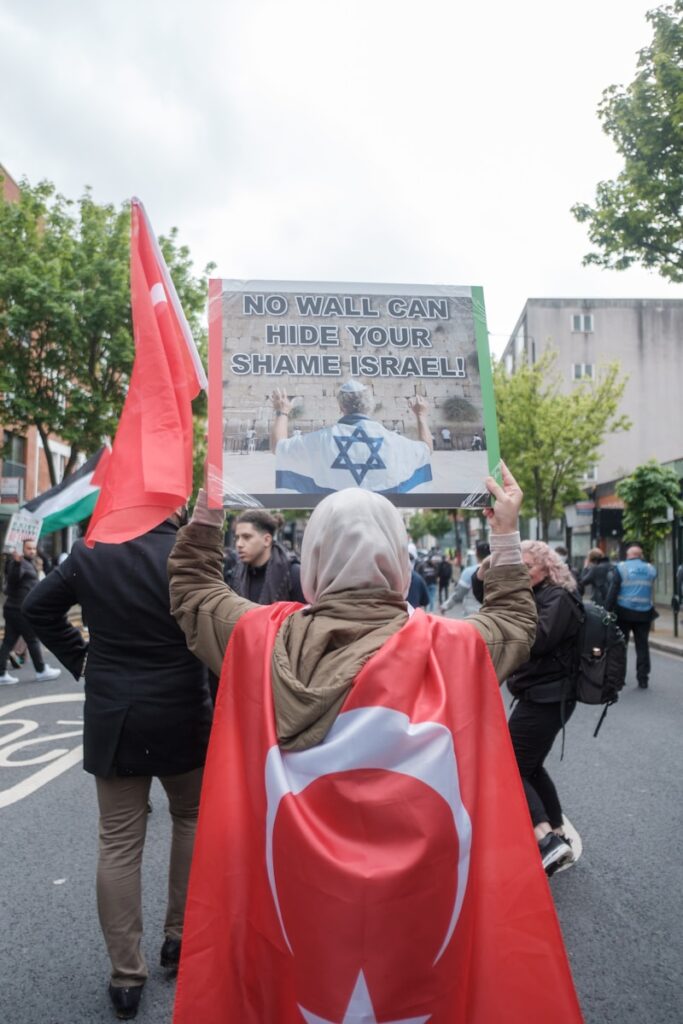 people in red and white hijab standing on street during daytime